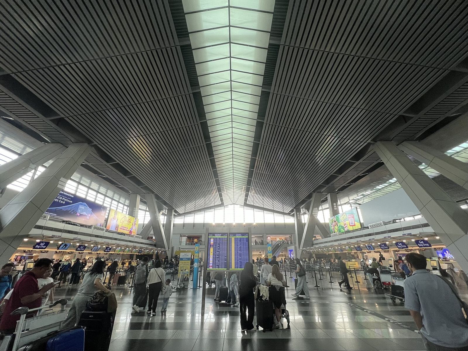 Long departure hall with a ribbed ceiling at NAIA Terminal 3, Manila