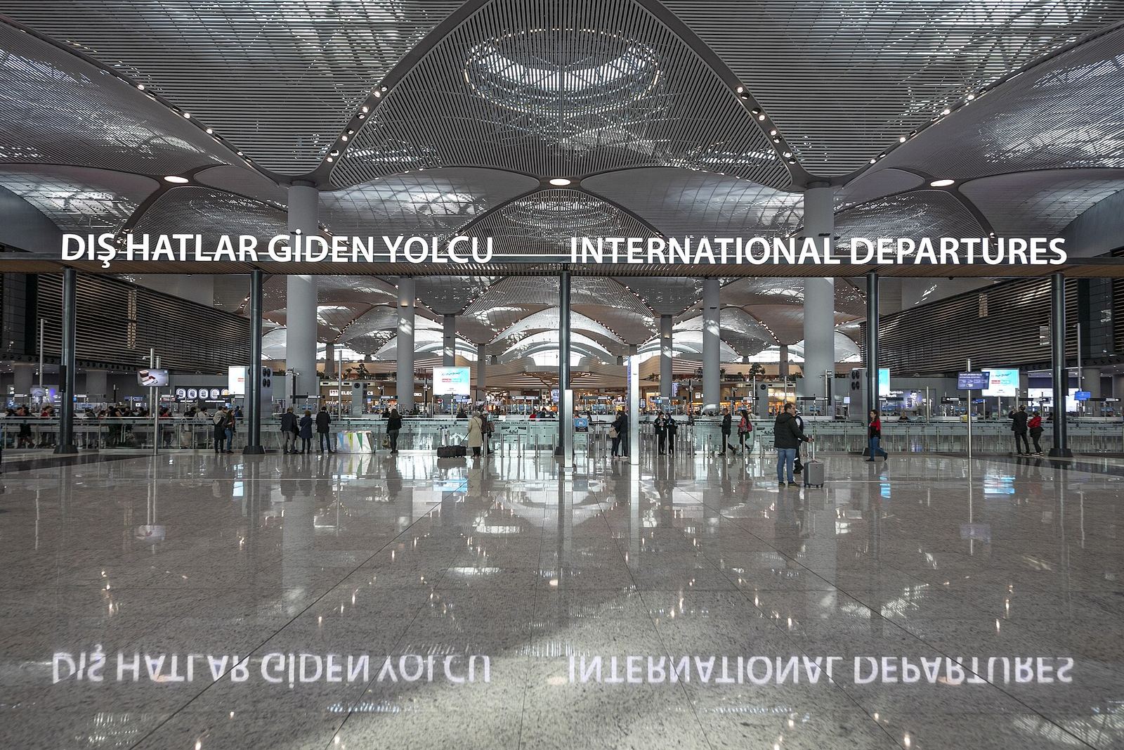 Vast, polished international departures hall at Istanbul Airport under a domed ceiling